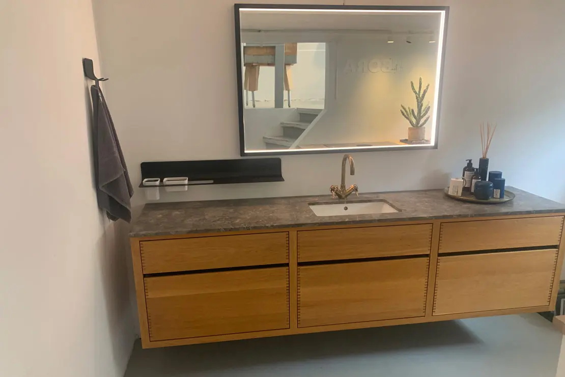 Piso del cuarto de baño revestido con microcemento de tonalidad gris profundo.